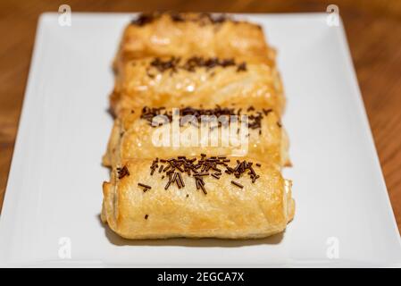 Pain au chocolat in Teller auf einem dunklen Holzhintergrund Stockfoto