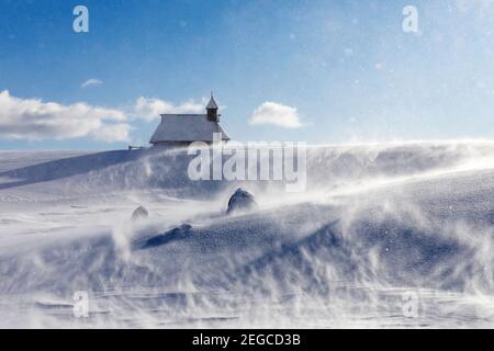 Kapelle der Schneemarie bei windigen Bedingungen auf der Velika planina Wiese, Slowenien Stockfoto