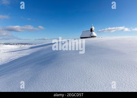 Kapelle der Schneemarie bei windigen Bedingungen auf der Velika planina Wiese, Slowenien Stockfoto