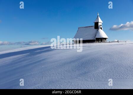 Kapelle der Schneemarie bei windigen Bedingungen auf der Velika planina Wiese, Slowenien Stockfoto