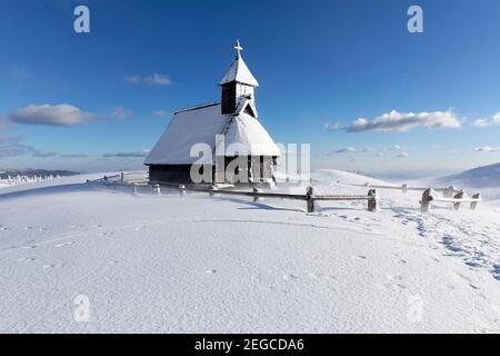 Kapelle der Schneemarie bei windigen Bedingungen auf der Velika planina Wiese, Slowenien Stockfoto