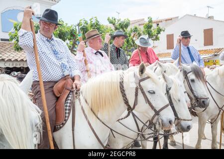 'Les Gardiens Camargaises', auf ihren Camargue-Pferden warten vor der Kirche von Saintes Marie de La Mer auf das Ende des Gottesdienstes und die Proce Stockfoto