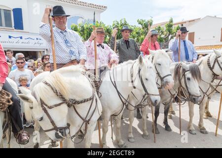 'Les Gardiens Camargaises', auf ihren Camargue-Pferden warten vor der Kirche von Saintes Marie de La Mer auf das Ende des Gottesdienstes und die Proce Stockfoto