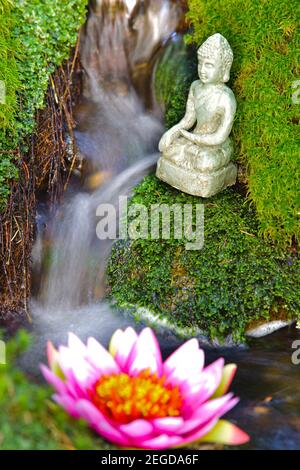 Buddha Skulptur sitzt im fliessenden Wasser Stockfoto