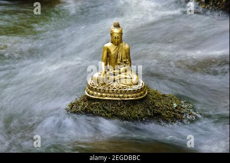 Buddha Skulptur sitzt im fliessenden Wasser Stockfoto