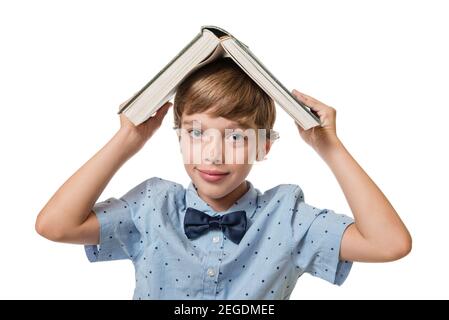 Kleiner Junge hält Buch über Kopf wie Dach, isoliert auf weißem Hintergrund Stockfoto