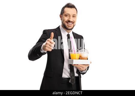 Junger Geschäftsmann mit Kaffee zum Mitnehmen und Orangensaft mit Daumen Oben isoliert auf weißem Hintergrund Stockfoto