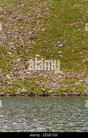 Ein paar Touristen stehen am Rande eines Bergsees, See Brebeneskul, der montenegrinischen Grat, die Karpaten von Ukraine,2020 Stockfoto