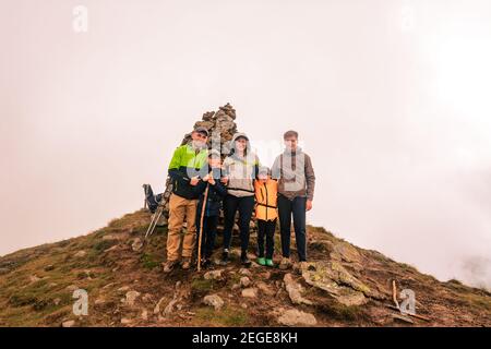 Eine Familie von Touristen auf einem wolkigen Berg in den Karpaten, der Berg von zweitausend Gutzin Tomnatyk, kühne Touristen in der mystischen weiß Stockfoto
