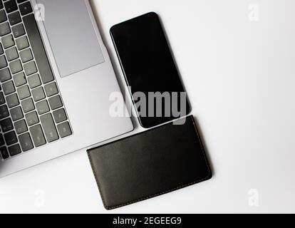 Arbeitsplatz mit Smartphone, Laptop auf weißem Hintergrund. Draufsicht, flach liegend. Speicherplatz kopieren. Stockfoto