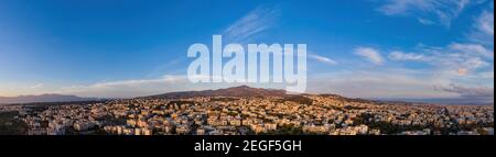 Athen, Griechenland Luftdrohne Panoramablick von Penteli Mount bei Sonnenuntergang. Sonnenuntergang über der griechischen Hauptstadt. Stockfoto