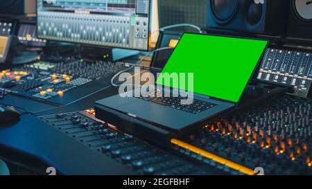 Modernes Music Record Studio Control Desk mit Green Screen Chroma Key Laptop, Equalizer, Mixer und anderen professionellen Geräten. Umschalter, Tasten Stockfoto