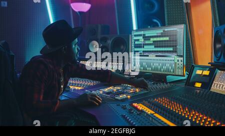 Stilvoller Audio Engineer Producer, der im Music Record Studio arbeitet. Computerbildschirm mit der Benutzeroberfläche der Digital Audio Workstation-Software Stockfoto