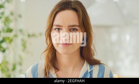 Authentische Schönheit Porträt Aufnahme einer schönen Brünette Frau in einem hellen Zimmer zu Hause. Pretty Young Woman posiert für die Kamera und sanft smiles Stockfoto
