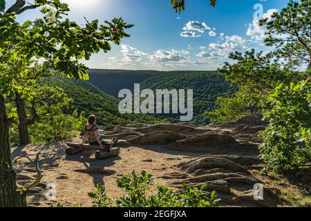 Ein Mädchen sitzt und genießt den Blick auf den Nationalpark Podyji in der südmährischen Region der Tschechischen Republik. Stockfoto