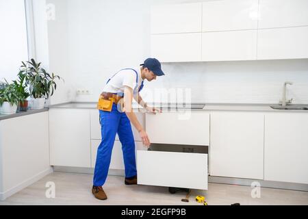 Junger Mann Montage Küchenmöbel. Stockfoto