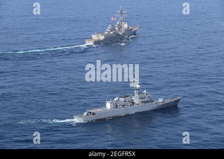 Ein US Navy Arleigh Burke-Klasse Lenkrakete Zerstörer USS James E. Williams, top, führt eine Passing-Übung mit der kolumbianischen Marine Fregatte ARC Antioquia während gemeinsamer Operationen 15. Februar 2021 in der Karibik. Stockfoto