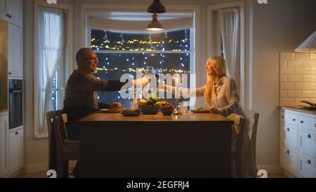 Happy Senior Pärchen in Love Haben romantische Abend, Toasting einander mit Gläsern Wein, feiern Jubiläum. Älterer, Reizender Mann, Frau Stockfoto