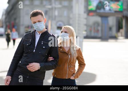 Junges Paar umarmt trägt eine Gesichtsschutzmaske in der Innenstadt, da neue Coronavirus entstanden sind. Stockfoto