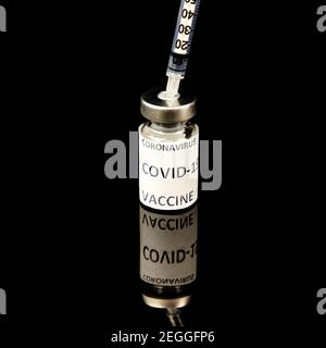 Impfstoffflasche mit Silberkappe Covid - 19 Coronavirus-Impfstoff, medizinische Spritze isoliert auf schwarz Stockfoto