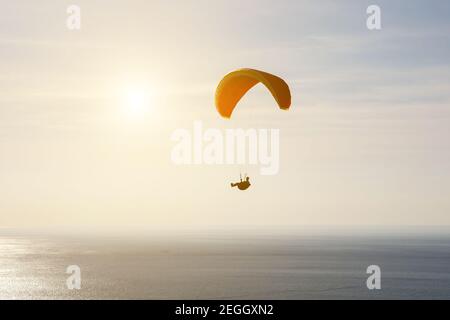 Mann auf einem Gleitschirm, Silhouette, Flug über das Meer Stockfoto