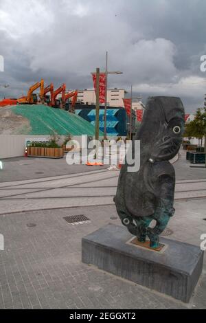 Maori Statue und Gruppe von Baggern auf Schotterhügel, Straßenrettung nach Chirstchurch Erdbeben, Neuseeland Stockfoto