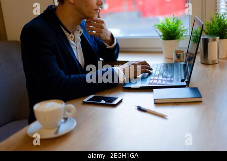 Junger Mann auf der Straße und im Café mit Mobile Telefon Stockfoto