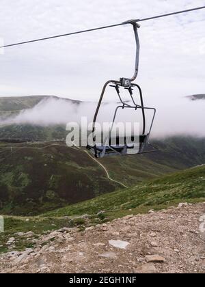 Blick über Glenshee von Cairnwell mit einem Sessellift, zeigt das Skizentrum im Sommer mit der vernarbten Landschaft auf dem Hügel gegenüber. Stockfoto