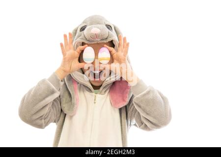 Mädchen im Hase Kostüm halten Ostereier und lachen. Isoliert auf weiß. osterfeiertagskonzept Stockfoto