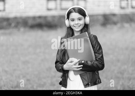 Mädchen hören Audio tragen Lehrbücher auf dem Weg zur Schule, Sprachunterricht Konzept. Stockfoto