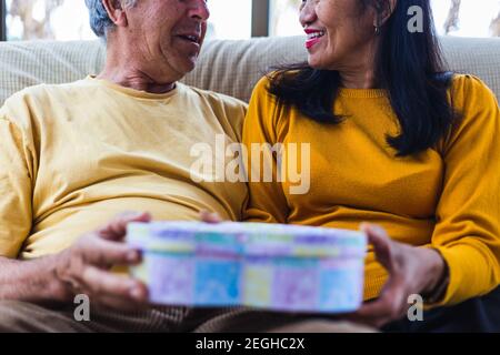 Nicht erkennbares Paar mittleren Alters, das ein Geschenk gibt Stockfoto