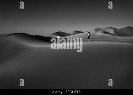 Schwarz-Weiß-Foto der schönen Wüste, durch die die Frau so frei zu Fuß. Genießen Sie die herrliche Schönheit der Liwa Wüste. Stockfoto