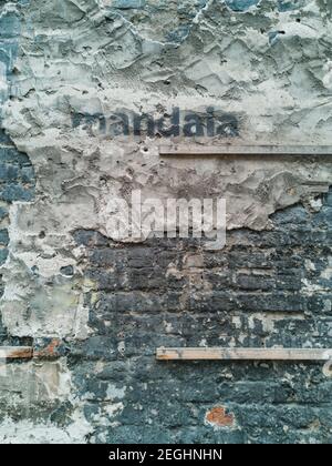 Grunge Wand des Gebäudes mit Holzlatten Zement und gesprüht Wort Stockfoto
