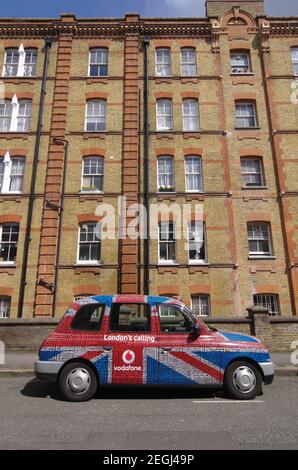 London, England - 25. Mai 2013: Ein traditionelles Londoner Taxi, das mit Vodafone, die 'London's Calling' in Form eines Union Jack anwirbt, bedeckt ist. Das Taxi Stockfoto