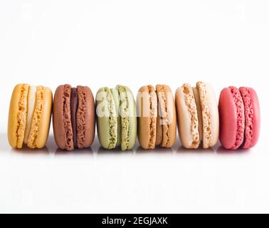 Bunte Macarons in einer Reihe auf weißem Hintergrund Stockfoto
