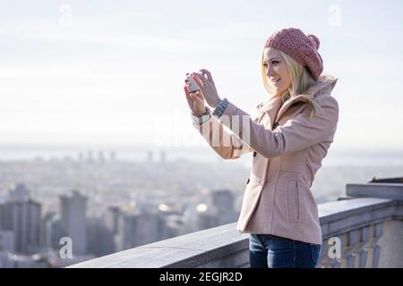 Junge blonde Frau mit Smartphone der Welt, Montreal, Quebec, Kanada Stockfoto