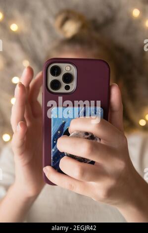 Nahaufnahme von Teen/Tween Girl mit Mobiltelefon, das von Lichtern beleuchtet wird Stockfoto