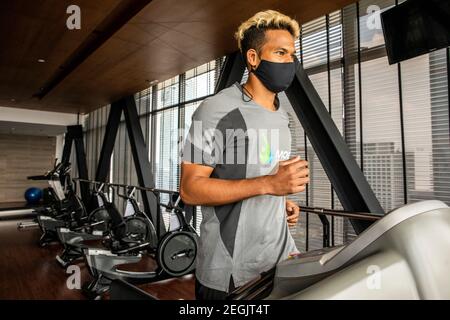 Fitness-Trainer demonstriert Sicherheit mit Maske und sozialer Distanzierung Stockfoto