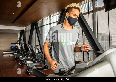 Fitness-Trainer demonstriert Sicherheit mit Maske und sozialer Distanzierung Stockfoto