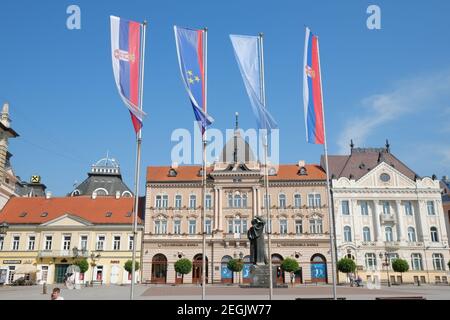 NOVI SAD, SERBIEN - AUGUST 03: Neoklassische Architektur auf dem Platz der Freiheit von Novi Sad und Flaggen von Serbien, Vojvodina und Novi Sad. Aufgenommen 2014 Stockfoto