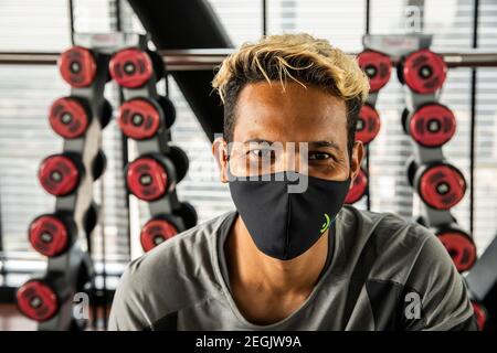 Porträt des Turntrainers, der vor dem Training unter Maske lächelt Stockfoto