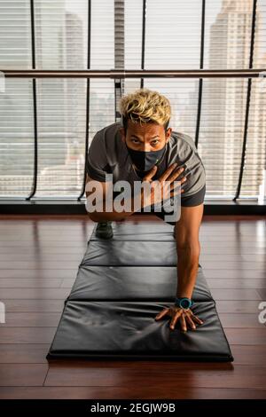 Fitness-Trainer demonstriert Sicherheit mit Maske und sozialer Distanzierung Stockfoto