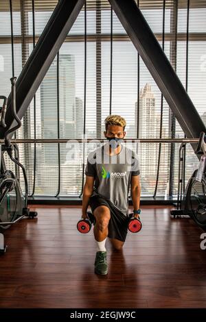 Fitness-Trainer demonstriert Sicherheit mit Maske und sozialer Distanzierung Stockfoto
