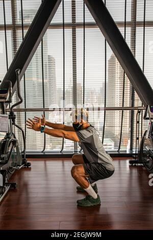 Fitness-Trainer demonstriert Sicherheit mit Maske und sozialer Distanzierung Stockfoto