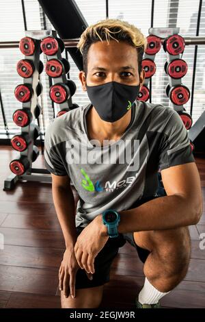 Fitness-Trainer demonstriert Sicherheit mit Maske und sozialer Distanzierung Stockfoto