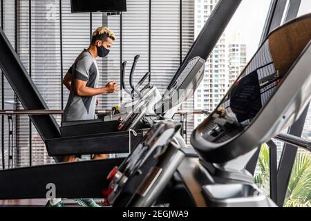 Fitness-Trainer demonstriert Sicherheit mit Maske und sozialer Distanzierung Stockfoto
