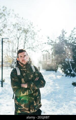 Junger Mann mit medizinischer Schutzmaske im Schnee Stockfoto