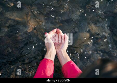 Die Hände einer Frau halten sauberes und natürliches Wasser in der Fluss Stockfoto