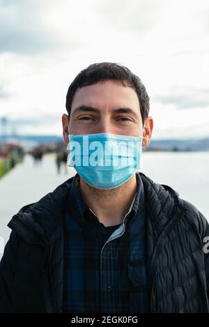 Junger Mann auf der Straße mit Gesichtsmaske Stockfoto