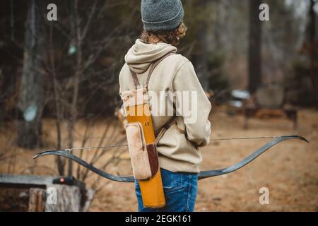 Teen junge mit vintage Köcher hält lange Bogen in Wisconsin Stockfoto